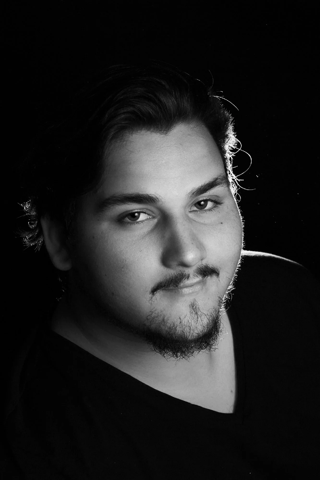 Black-and-white portrait of a young man looking upward toward the camera