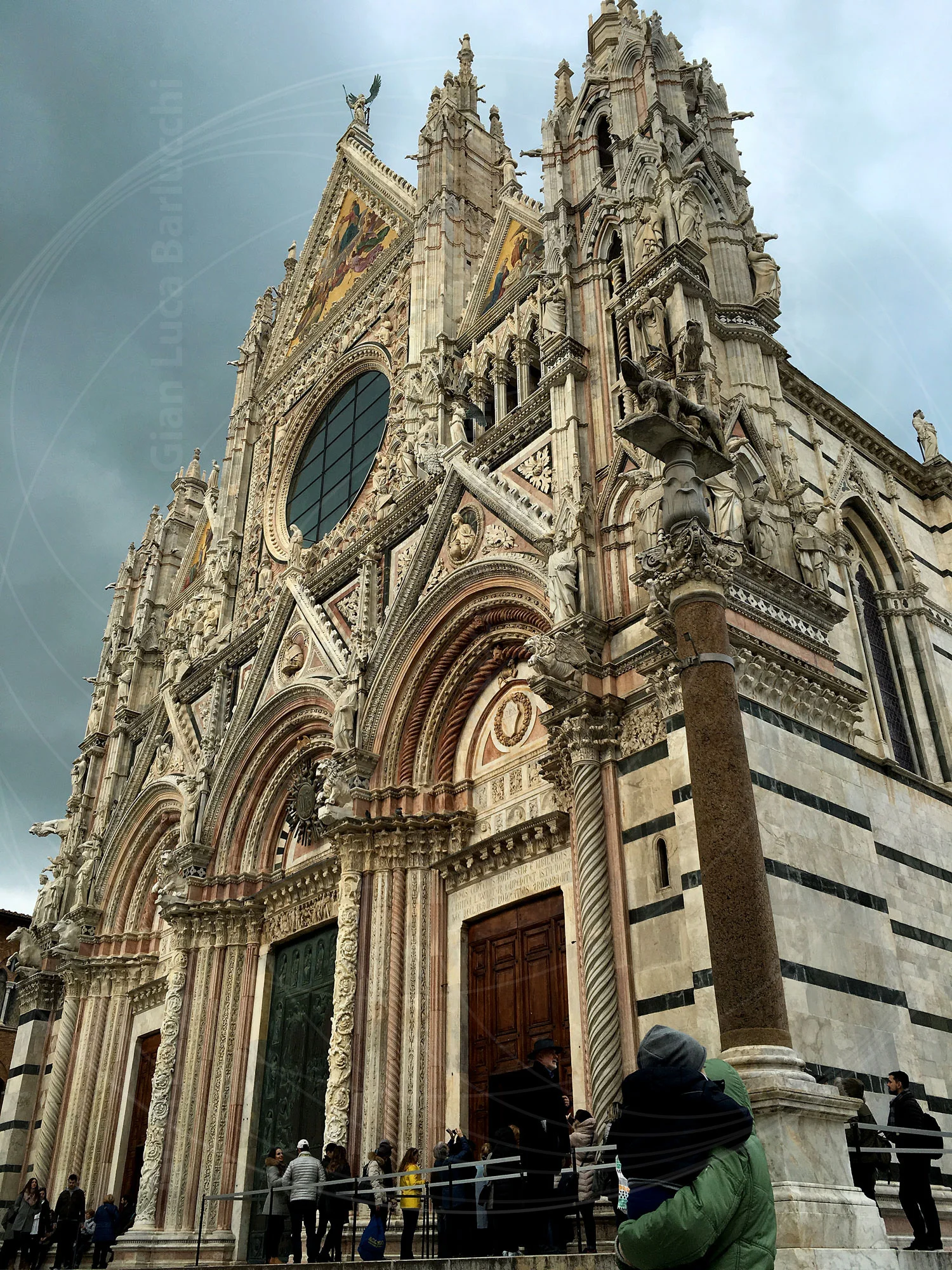 Ornate striped facade and rose window of Siena Cathedral