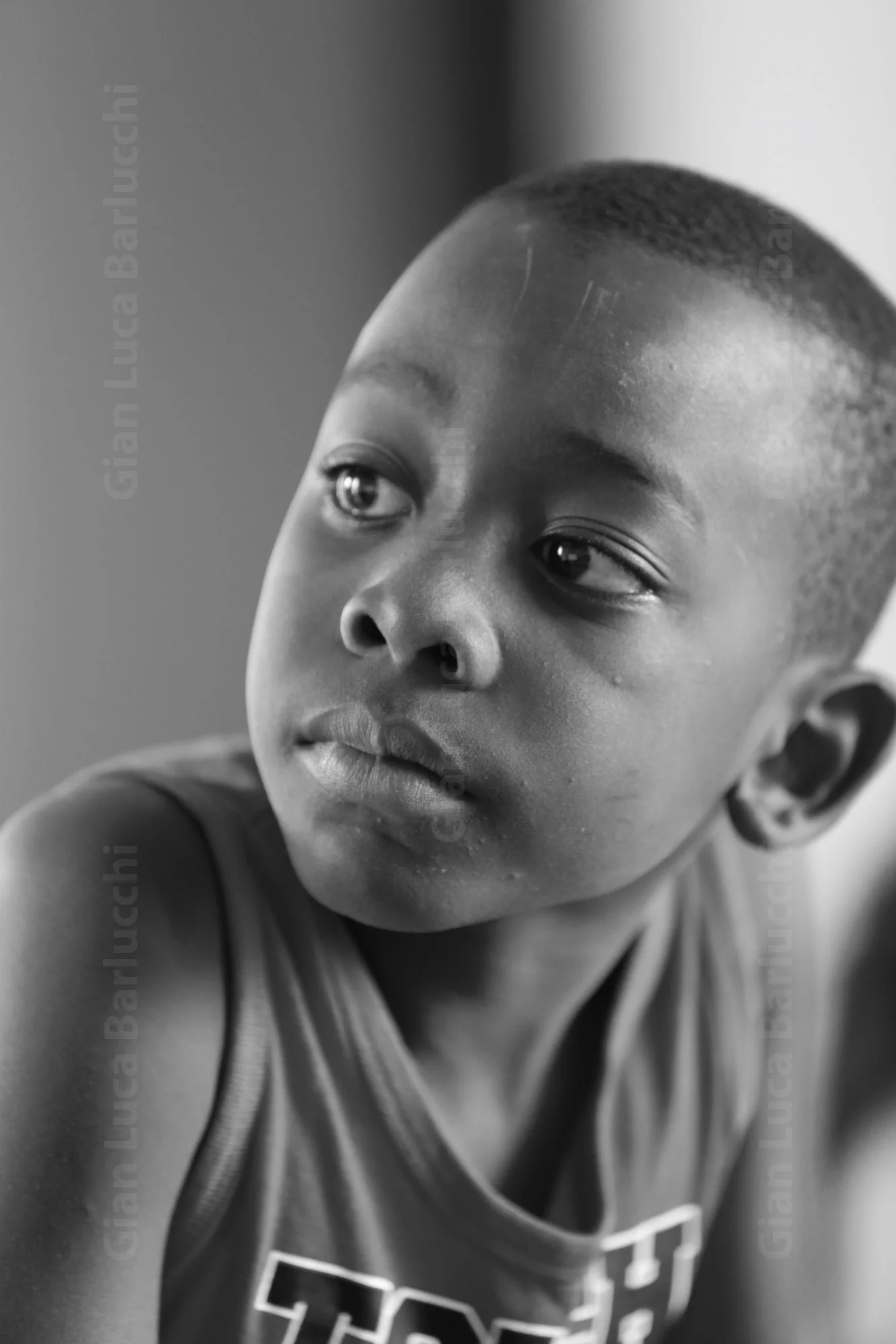 Black-and-white portrait of a child looking upward to the side