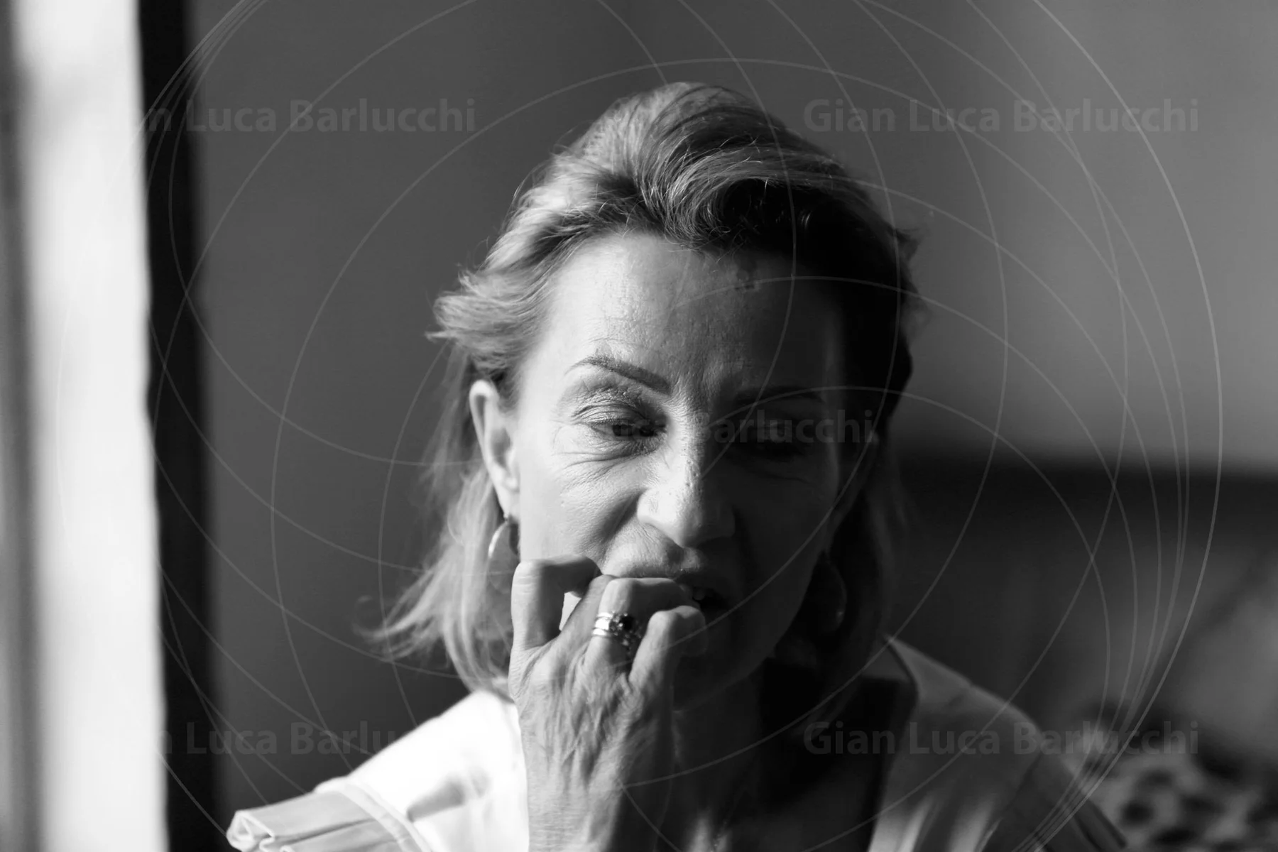 Black-and-white portrait of a woman with one hand near her mouth