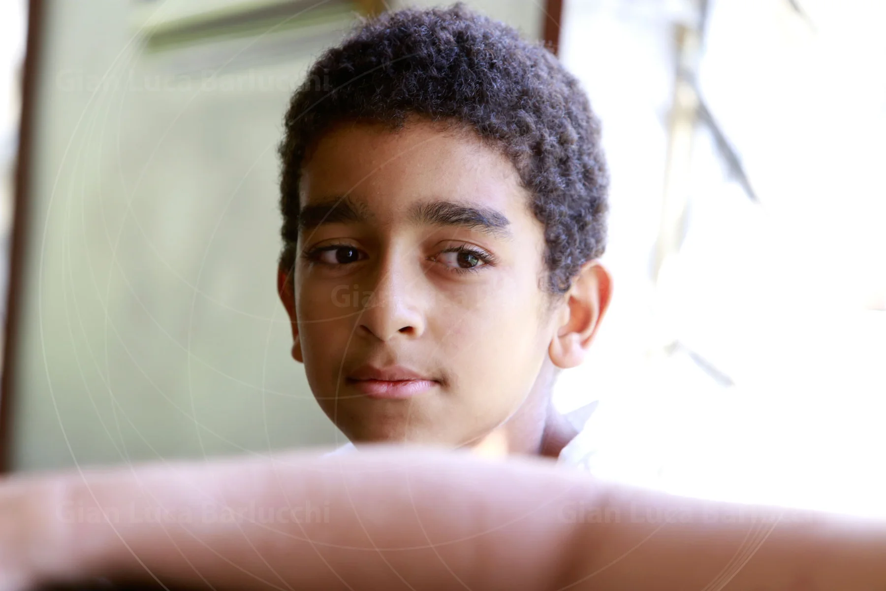 Young person resting their arms on the back of a chair