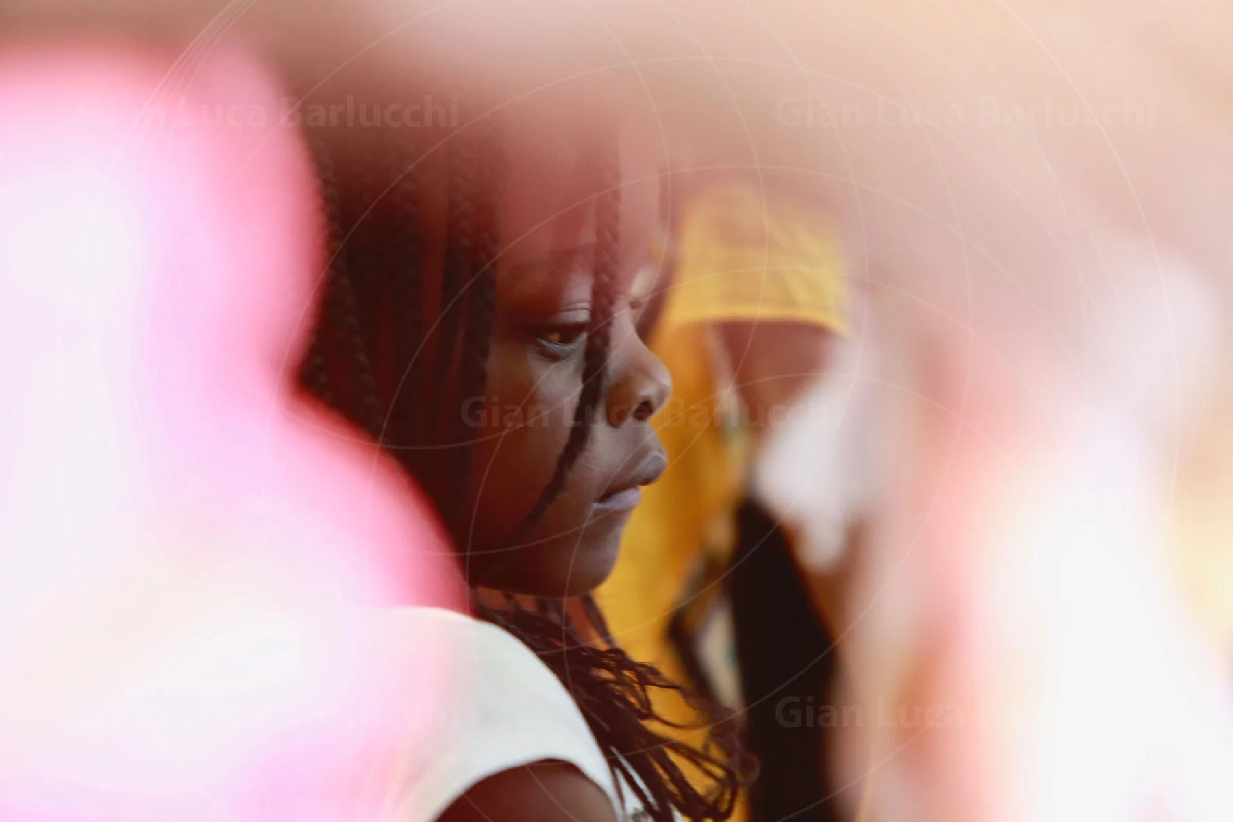 Child in profile seen through softly blurred pink foreground shapes