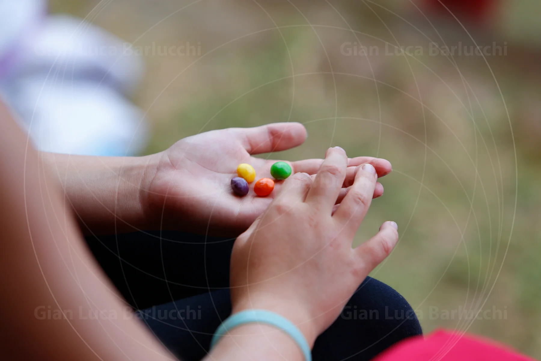 Child’s hands holding a few brightly coloured sweets