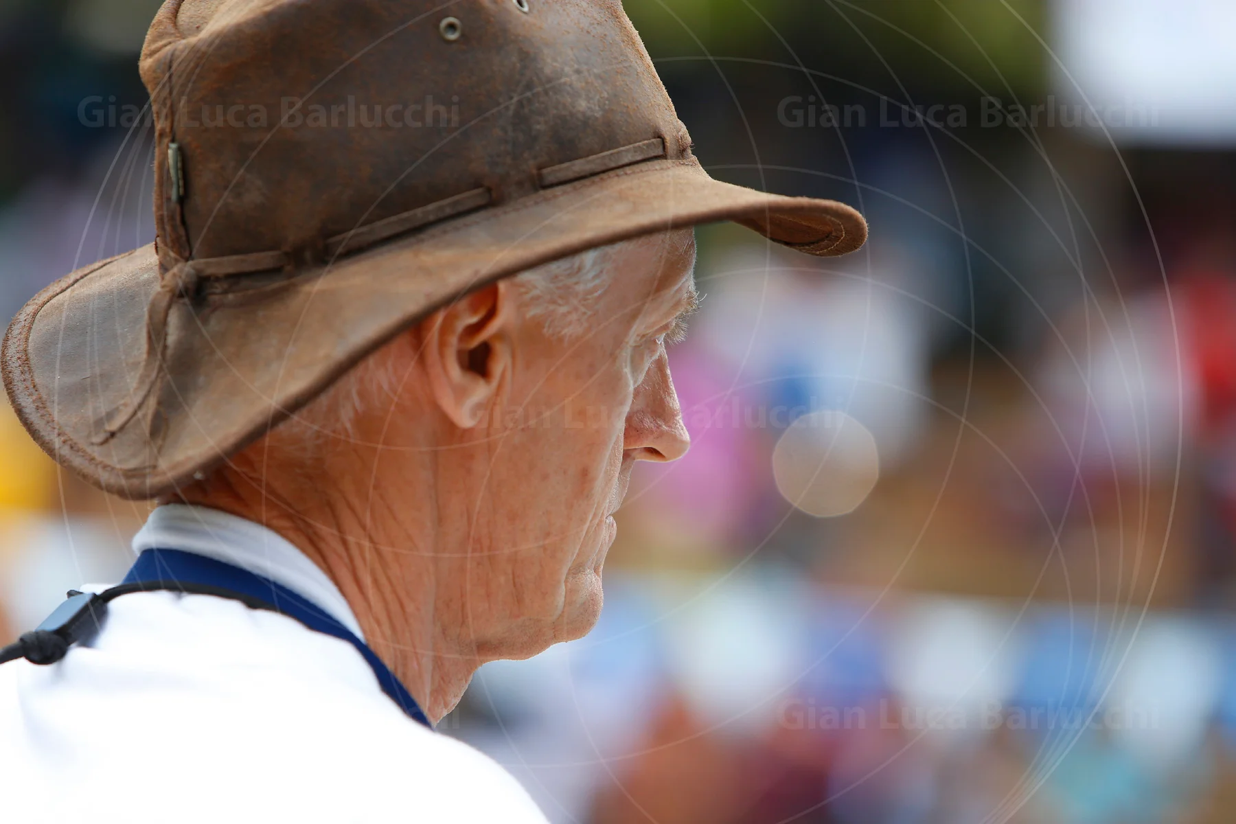 Side profile of a man wearing a brown brimmed hat outdoors