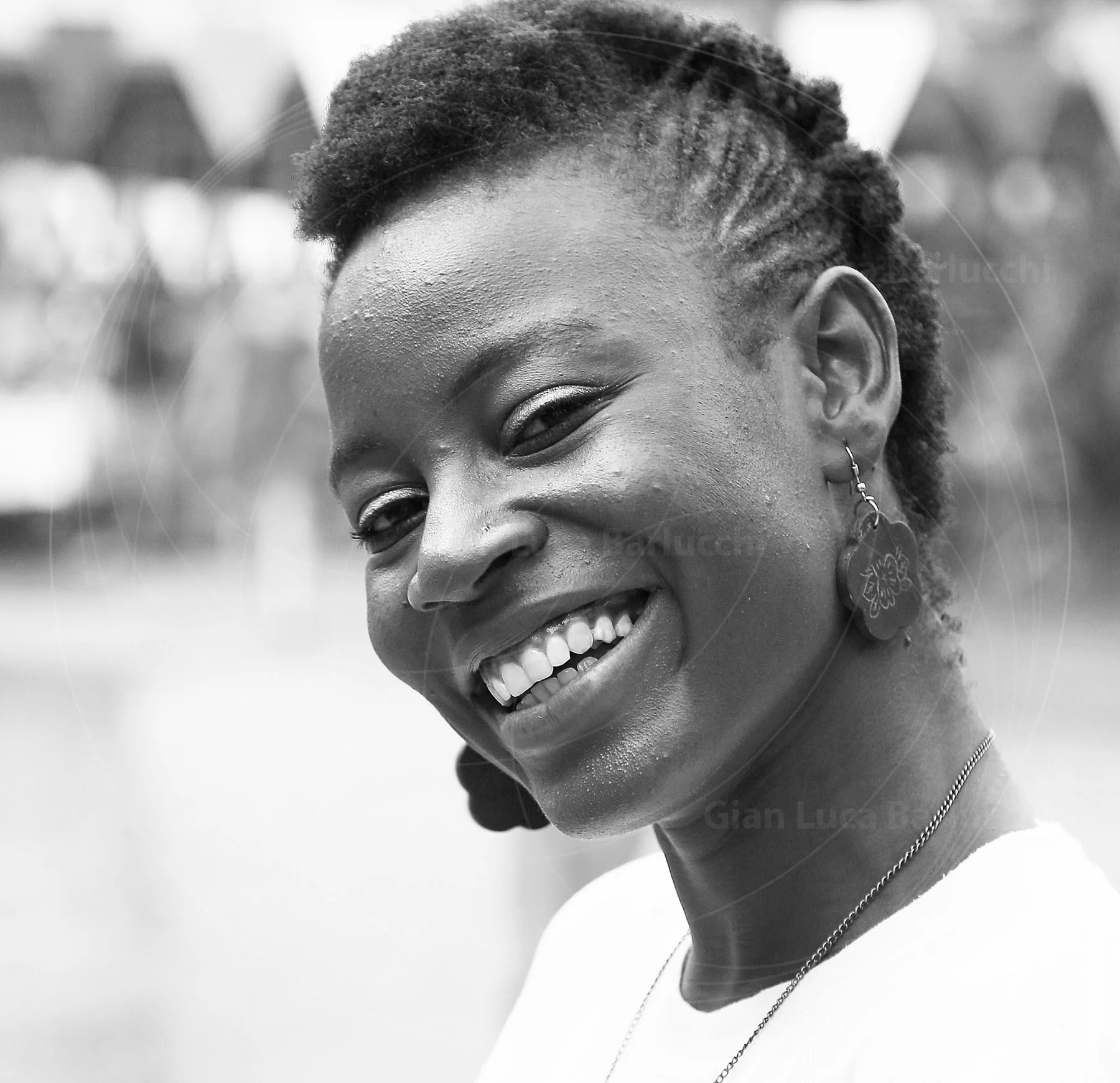 Black-and-white portrait of a smiling woman looking over her shoulder