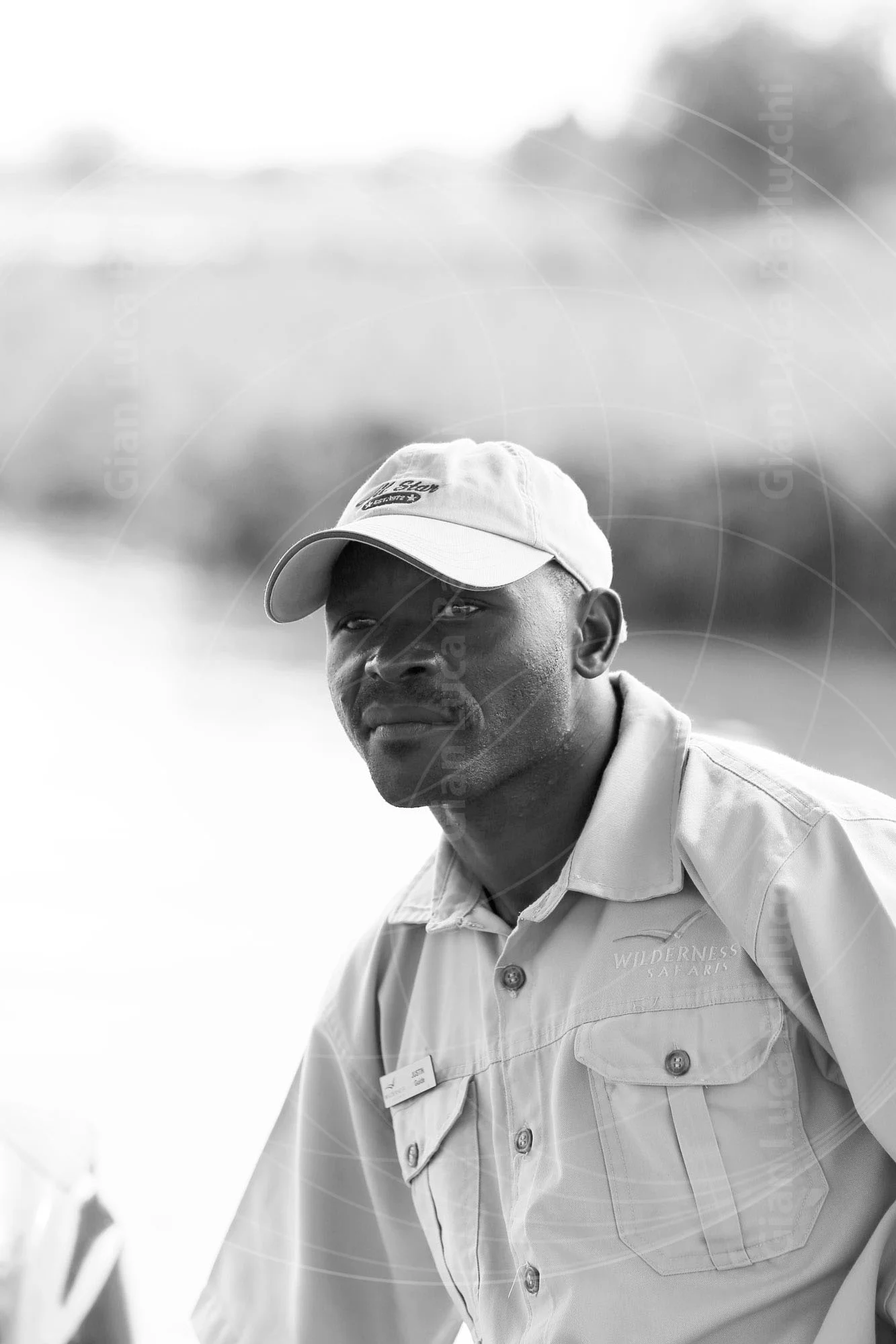 Black-and-white portrait of a man wearing a light baseball cap
