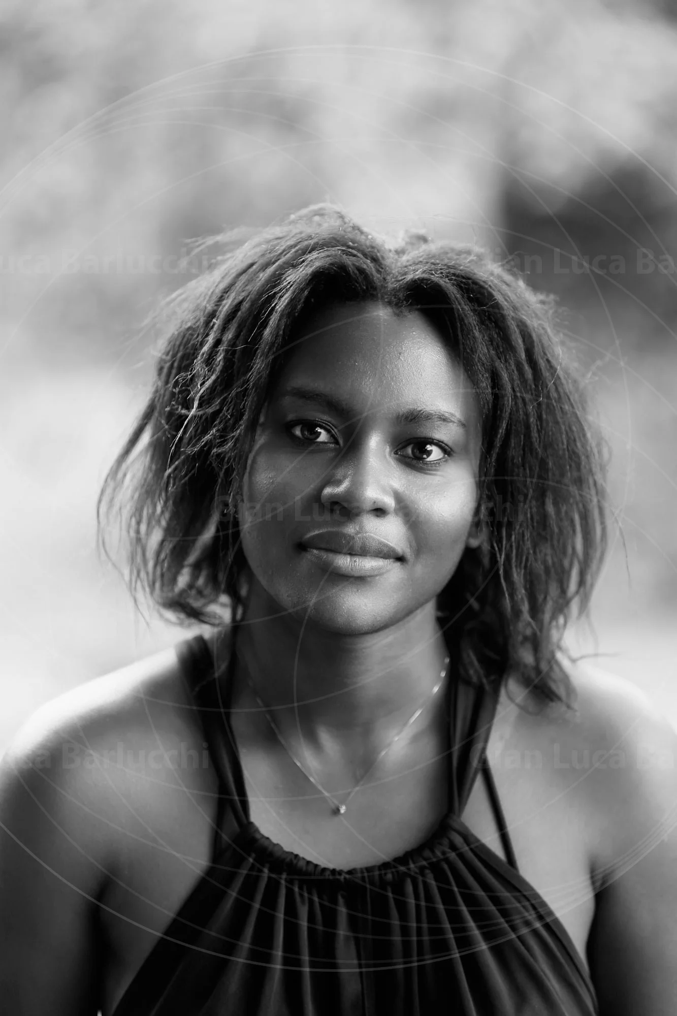 Black-and-white portrait of a woman with loose hair looking toward the camera